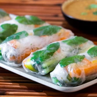 Cold Thai spring roll recipe with instructions for how to make with ripe paper, shrimp or chicken with vermicelli, Thai basil, carrots, cucumbers & mangos.