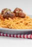 A plate of spaghetti topped with four meatballs and sauce.