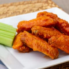 Restaurant style buffalo chicken wings made at home. Easy to prepare wings recipe with a traditional hot and spicy sauce using Frank's or other hot sauce. Great deep fried tail gate party snack.