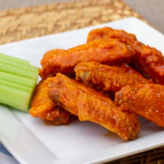 Restaurant style buffalo chicken wings made at home. Easy to prepare wings recipe with a traditional hot and spicy sauce using Frank's or other hot sauce. Great deep fried tail gate party snack.