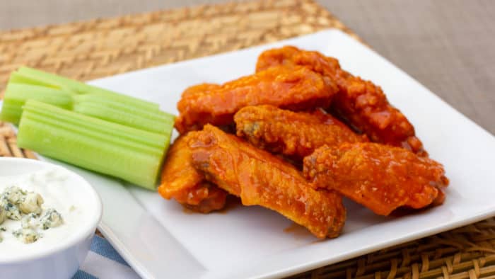 Restaurant style buffalo chicken wings made at home. Easy to prepare wings recipe with a traditional hot and spicy sauce using Frank's or other hot sauce. Great deep fried tail gate party snack.