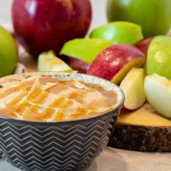 Bowl of creamy caramel dip with sliced apples