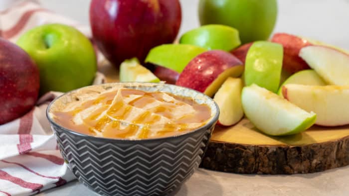 Bowl of creamy caramel dip with sliced apples