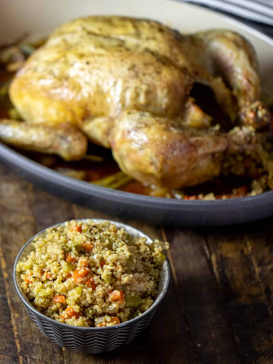 Angled picture of a bowl of stuffing with the roasted chicken in the back.