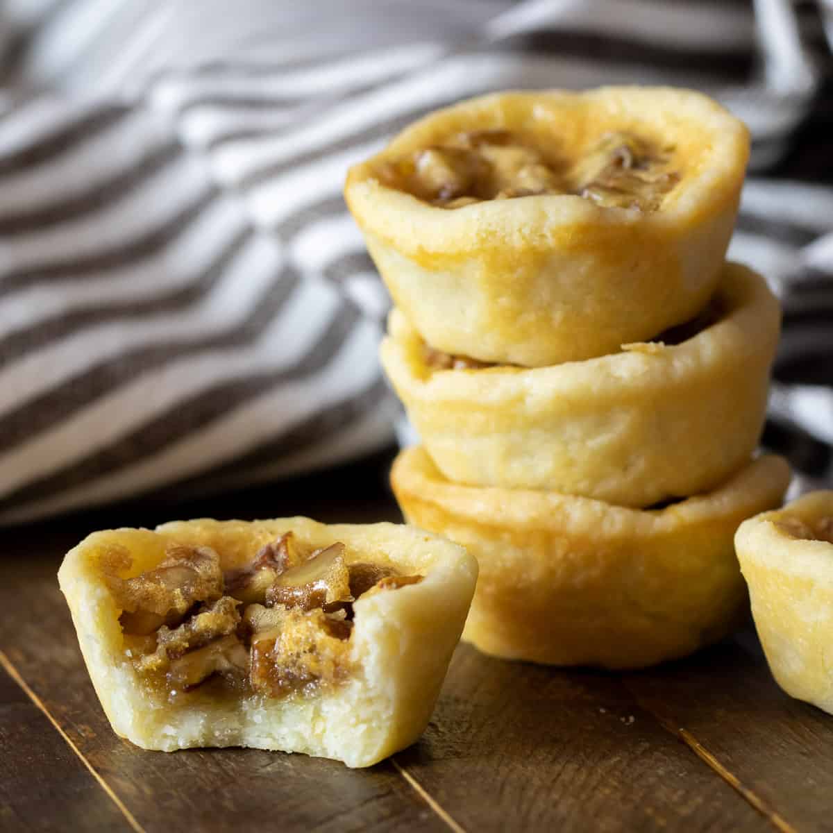 An angled picture of 5 desserts and one has a bite taken out of it.