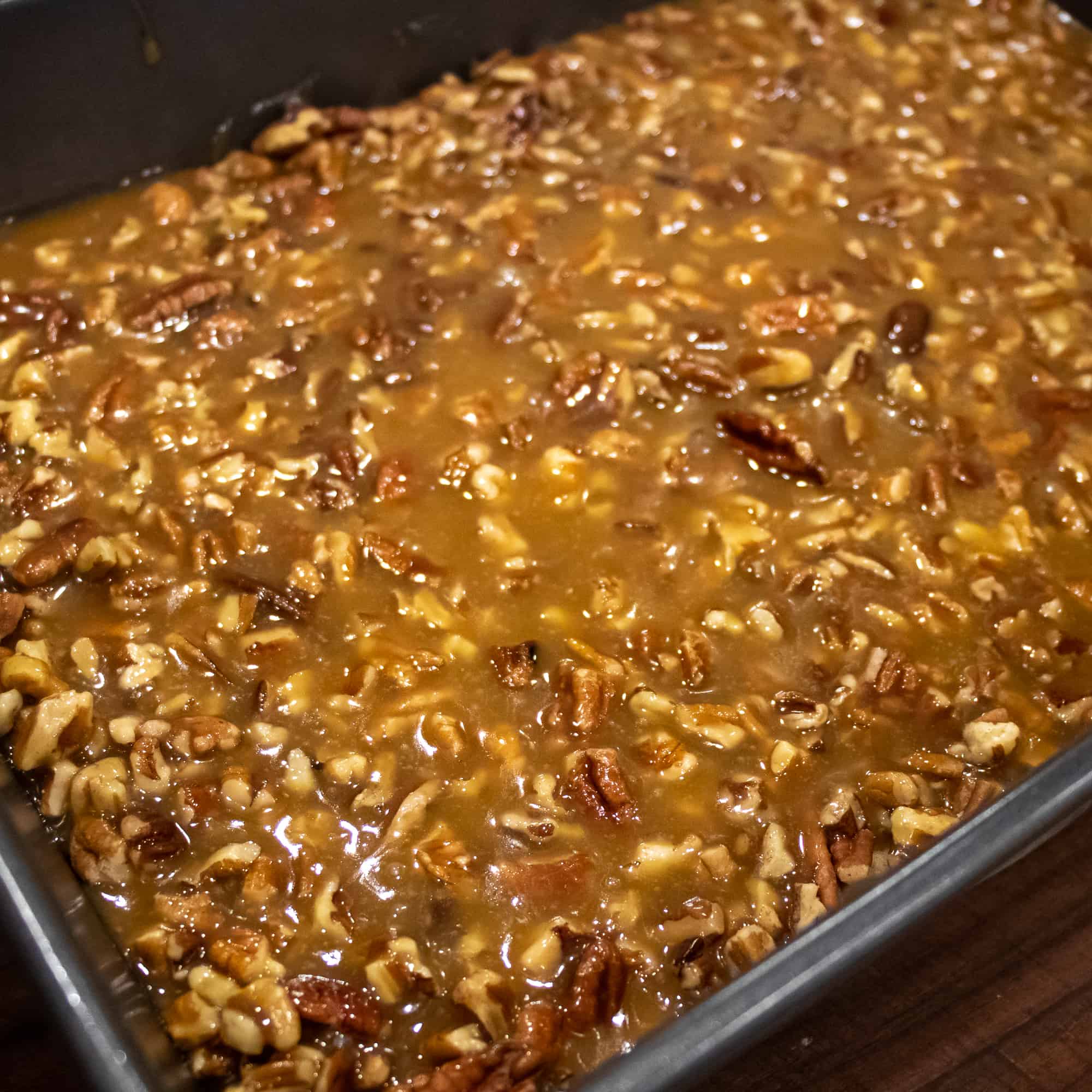 Pour the caramel and pecans over the crust layer.