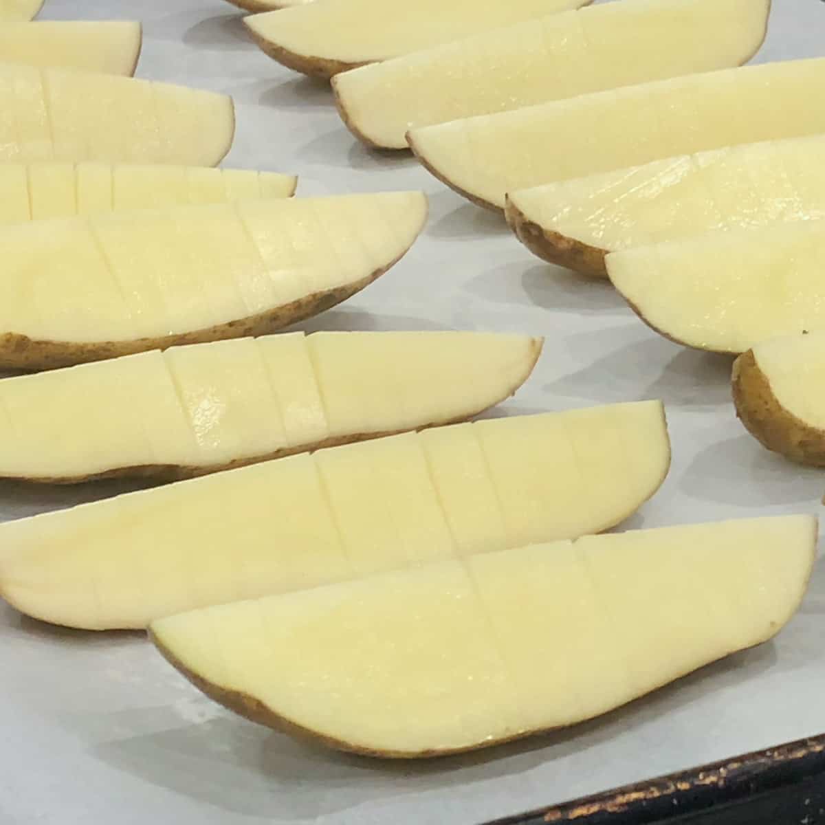 Russet Potatoes cut into quarters and then sliced hasselback style