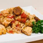 Instructions for how to make jambalaya. This classic Cajun and Creole dish uses chicken and andouille along with onions, celery and peppers and baked with rice.