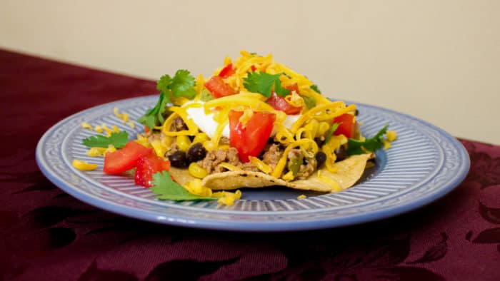 A fresh take on a Mexican classic. This healthy option uses ground chicken, black beans and corn in the meat mixture instead of ground beef. Top it with cheese, tomatoes, sour cream and guacamole and you have a winner!