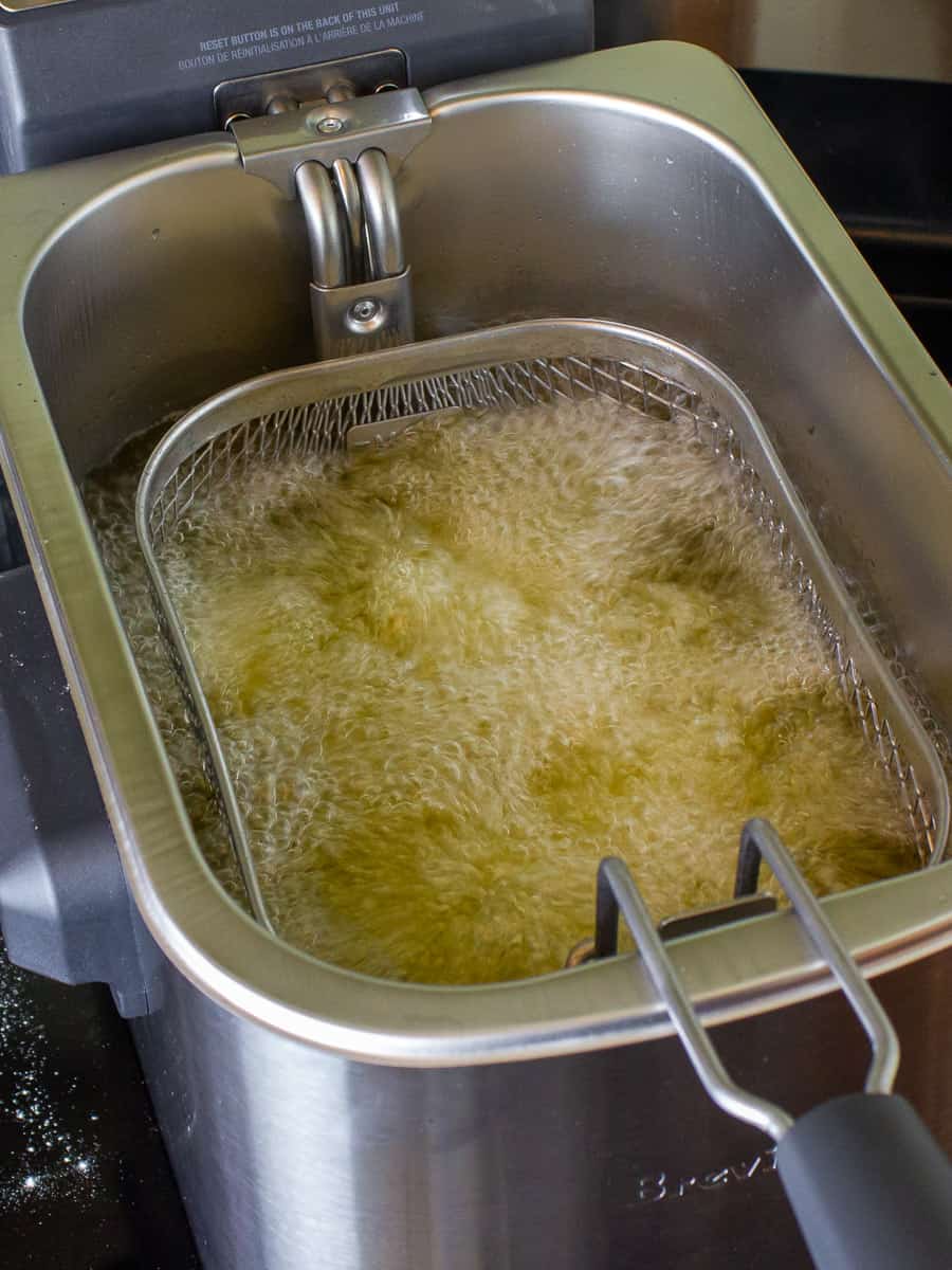 Chicken wings frying in hot oil.