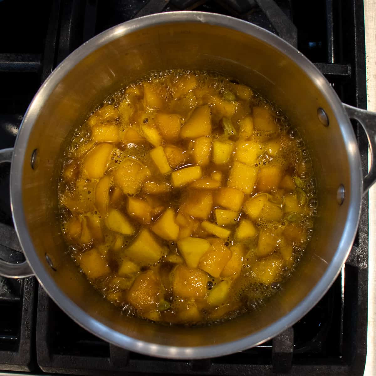 Diced mangos simmering in a saucepan.