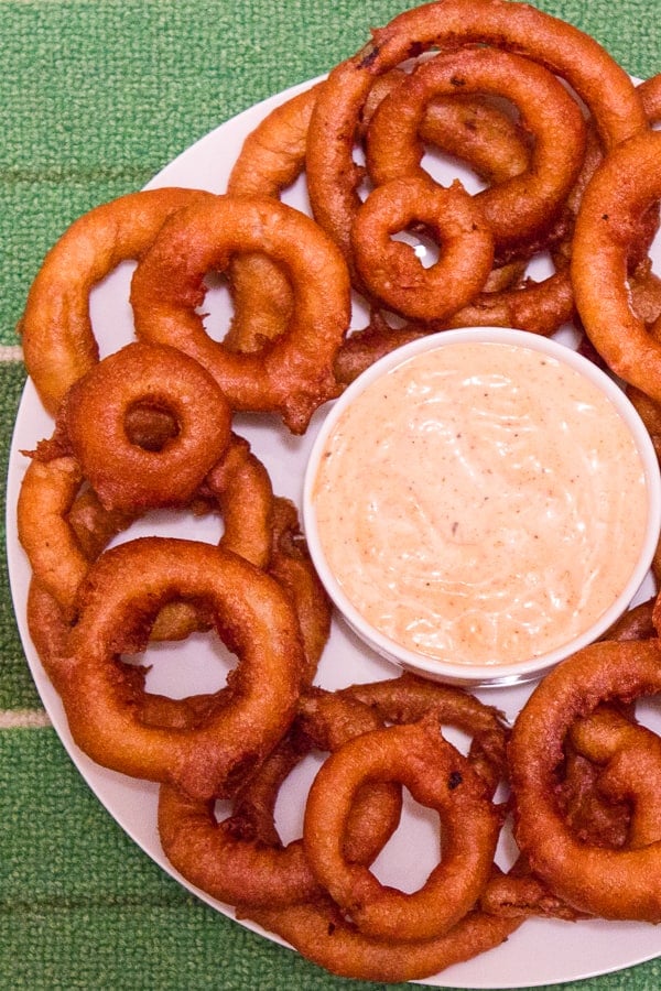 Light and crispy onion rings recipe that are deep fried in a beer batter coating with a cajun dip similar to the kind from Outback Steakhouses Bloomin' Onion.