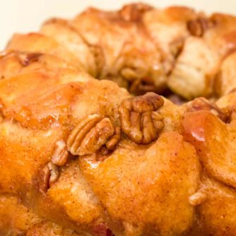 How to make monkey bread recipe with Pillsbury biscuit tubes and then has a caramel mixture that is poured over top and coats the pecans and monkey bread.