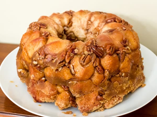 How to make monkey bread recipe with Pillsbury biscuit tubes and then has a caramel mixture that is poured over top and coats the pecans and monkey bread. 