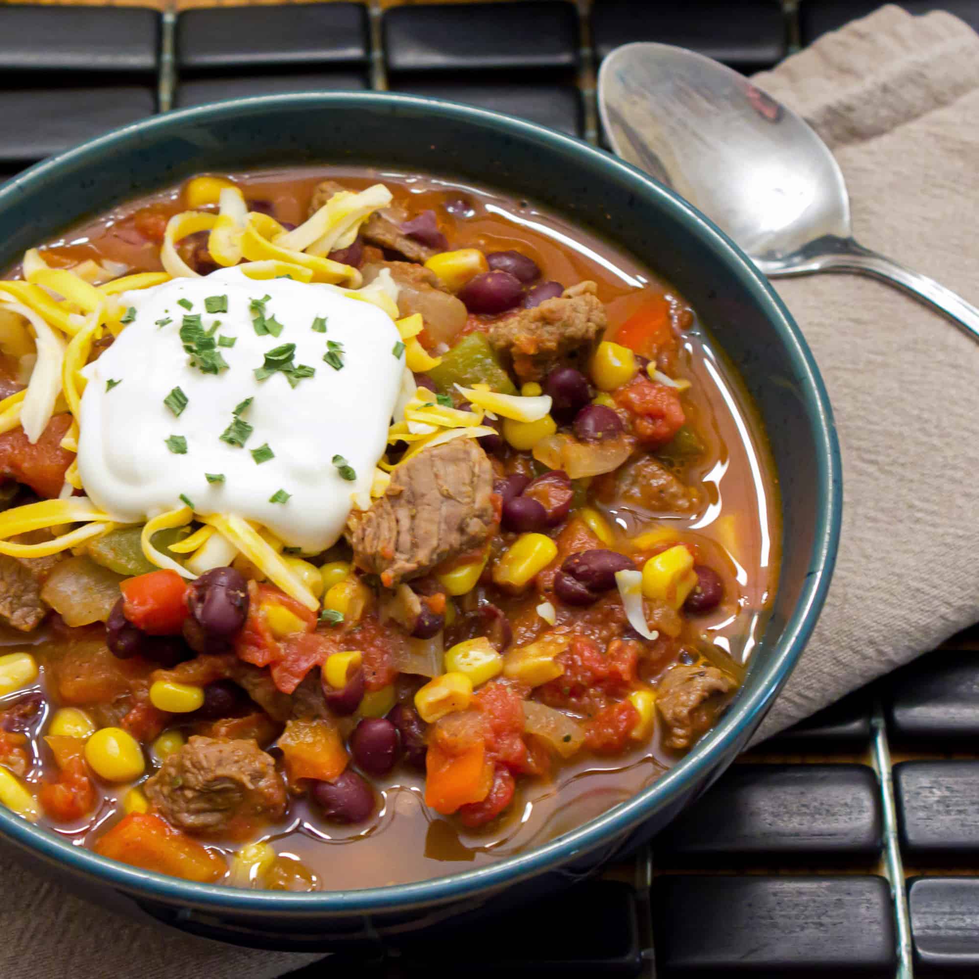 Hearty chili recipe with cubes of steak, black beans and corn. This is serious chili made for people who need a serious meal! 