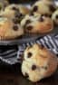 Muffin tray with chocolate chip muffins with a striped tea towel