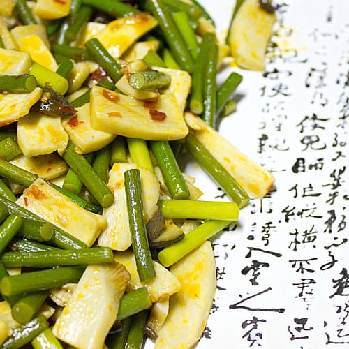 This spicy stir fry uses two common Asian ingredients. King Oyster Mushrooms and garlic stems are fried in a chili Sambal Oelek sauce (similar to Sriracha).