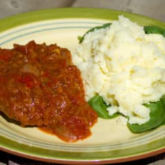 Swiss steak takes a cheap and tough cut of beef like round or sirloin steak (cube or minute), which is then braised in stewed tomatoes and other vegetables.
