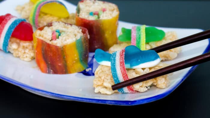 Instructions for how to make candy sushi with Rice Krispie treats, fruit roll ups, gummy worms, swedish fish, licorice strings and gummy sharks.