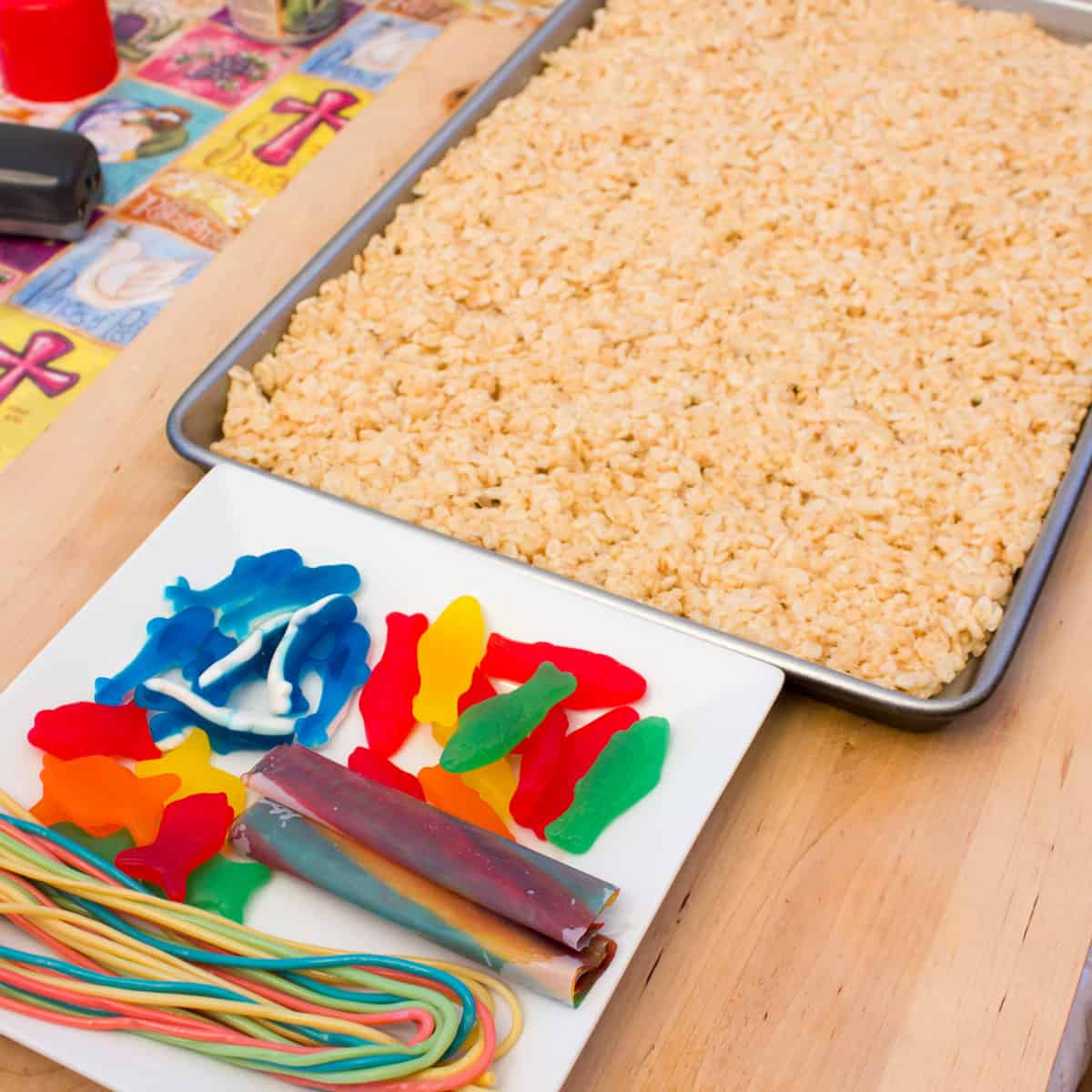 A tray of rice krispie squares, and gummy candy