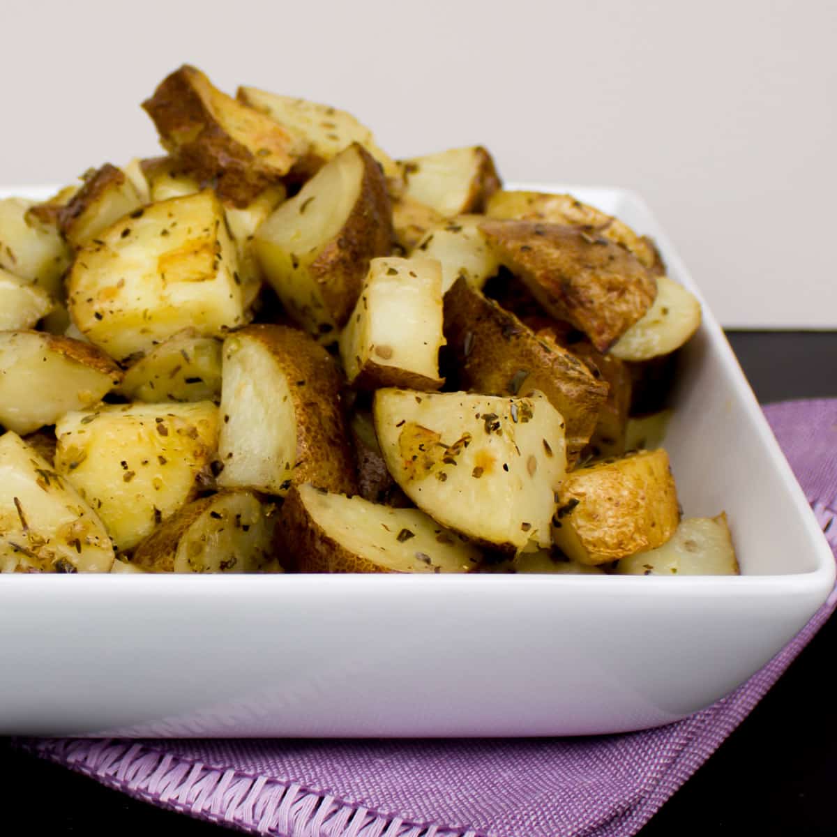 Side image of lemon roasted potato es in a bowl.