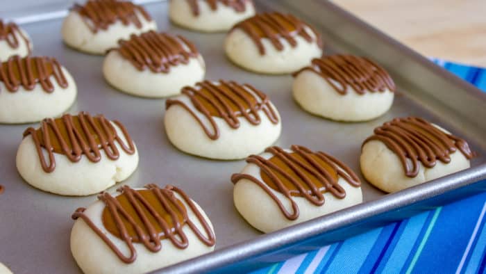 A recipe for a shortbread thumbprint cookie filled with dulce de leche and drizzled with melted chocolate. Tastes similar to a Twix candy bar with the caramel and chocolate.