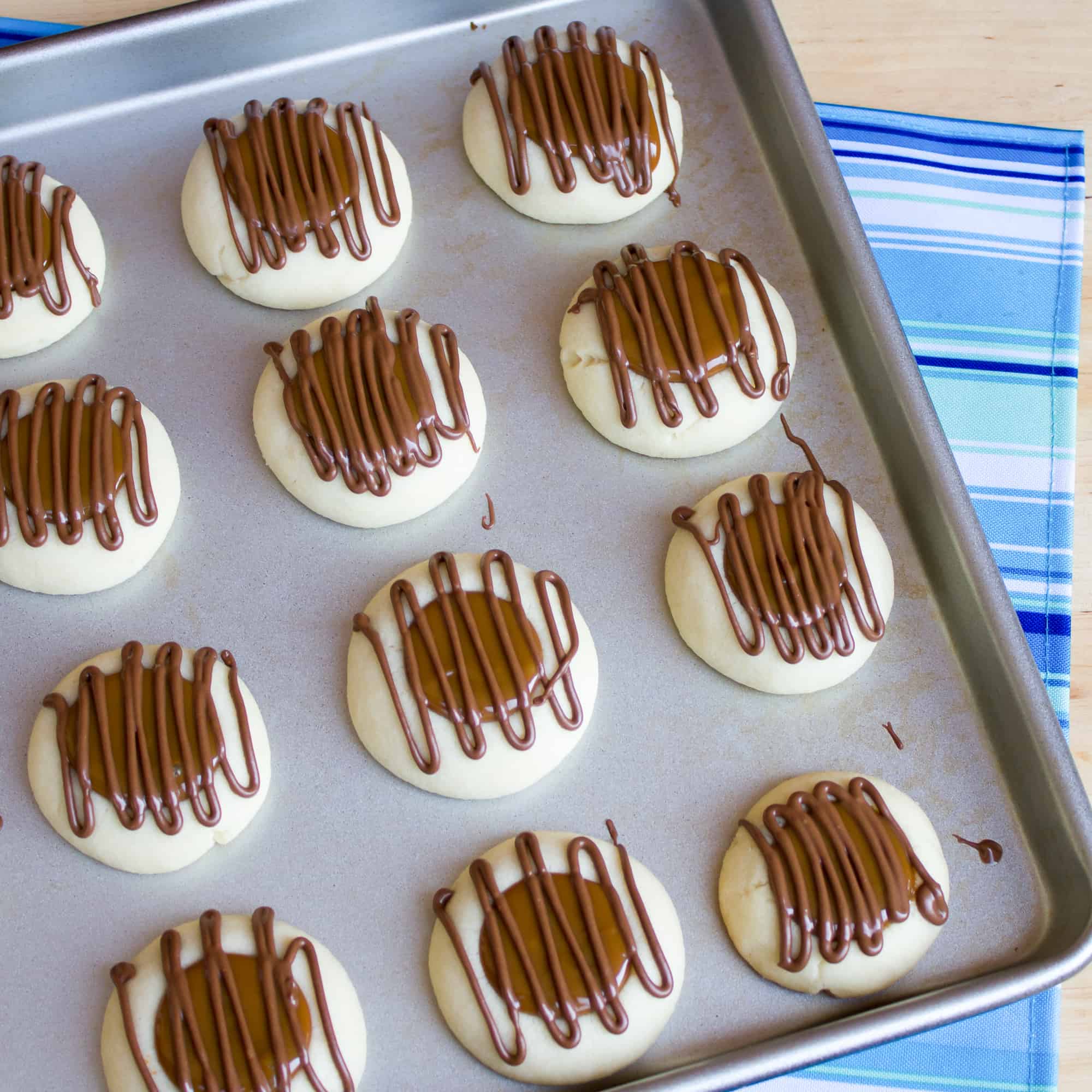 A recipe for a shortbread thumbprint cookie filled with dulce de leche and drizzled with melted chocolate. Tastes similar to a Twix candy bar with the caramel and chocolate. 