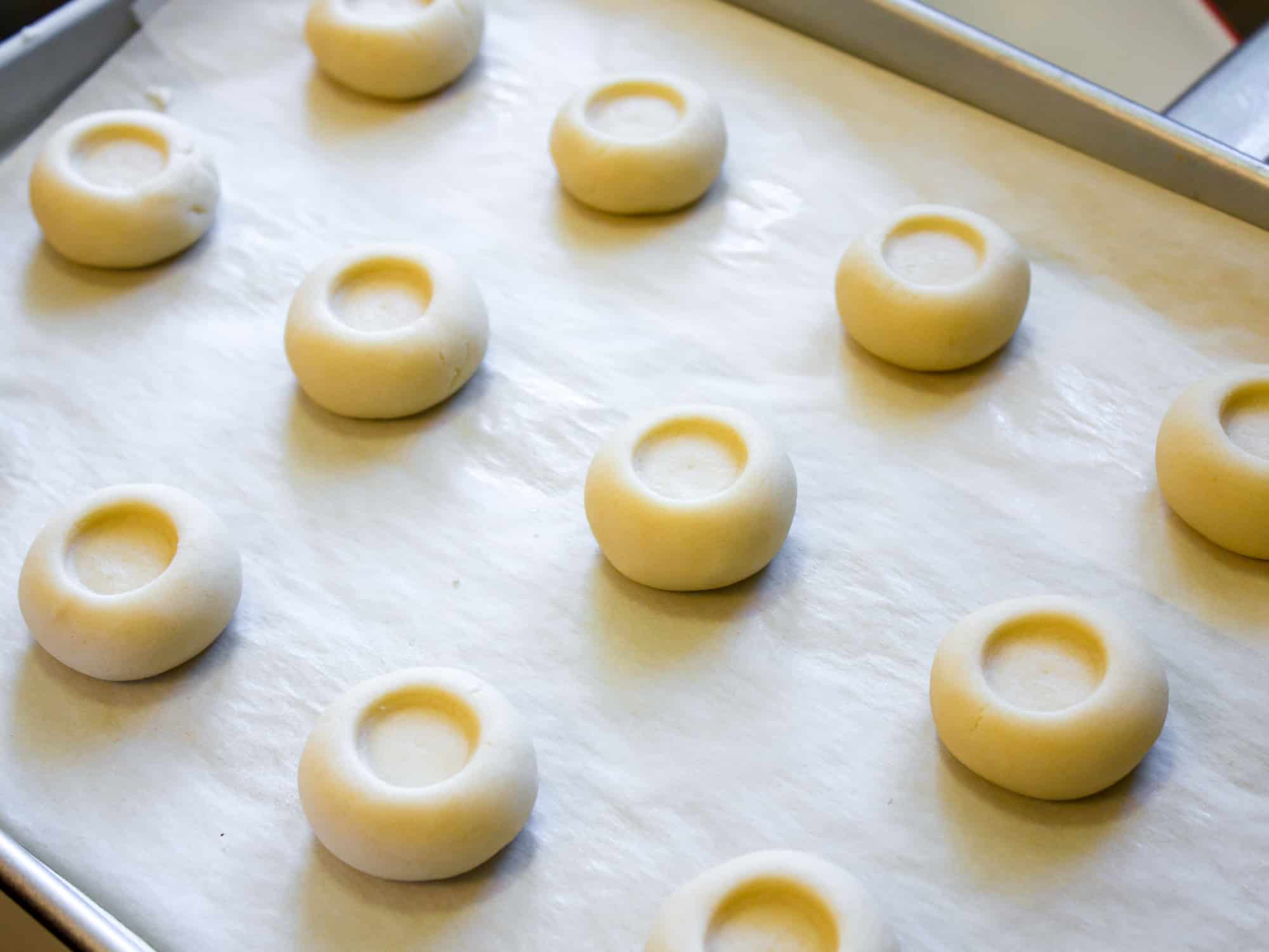 Roll the shortbread dough into a ball and make an indentation with your thumb or the cap of a chapstick.