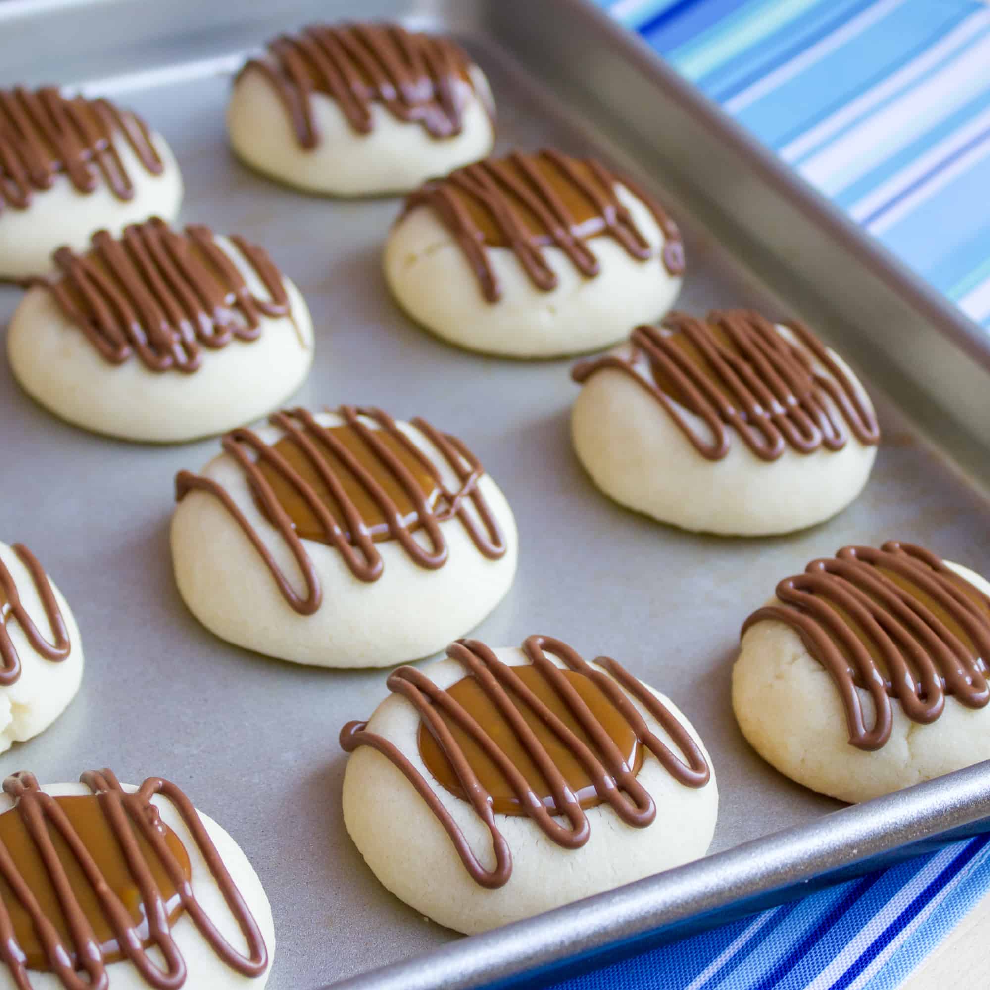 A recipe for a shortbread thumbprint cookie filled with dulce de leche and drizzled with melted chocolate. Tastes similar to a Twix candy bar with the caramel and chocolate. 