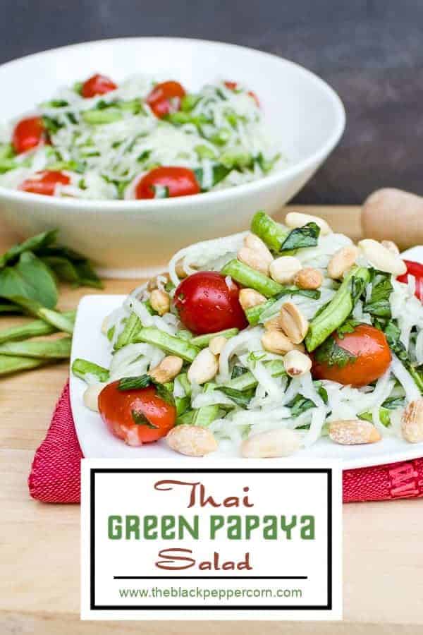 Thai green papaya salad with grape tomatoes, peanuts, long green beans, thai basil, cilantro and a dressing made of lime juice, oil, fish sauce, sugar, thai chilies.