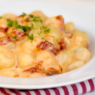 A bowl of gnocchi in a cream sauce.