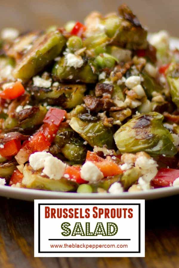 Roasted Brussels sprout salad recipe with bacon, walnuts, feta cheese, green onions, re peppers and a balsamic vinaigrette.