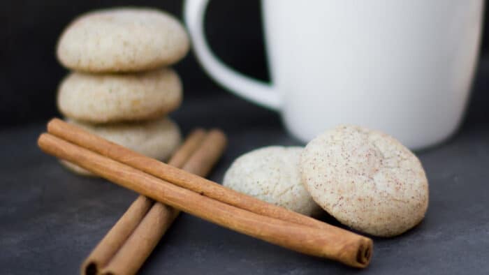 Round cookies piled together and next to cinnamon sticks.