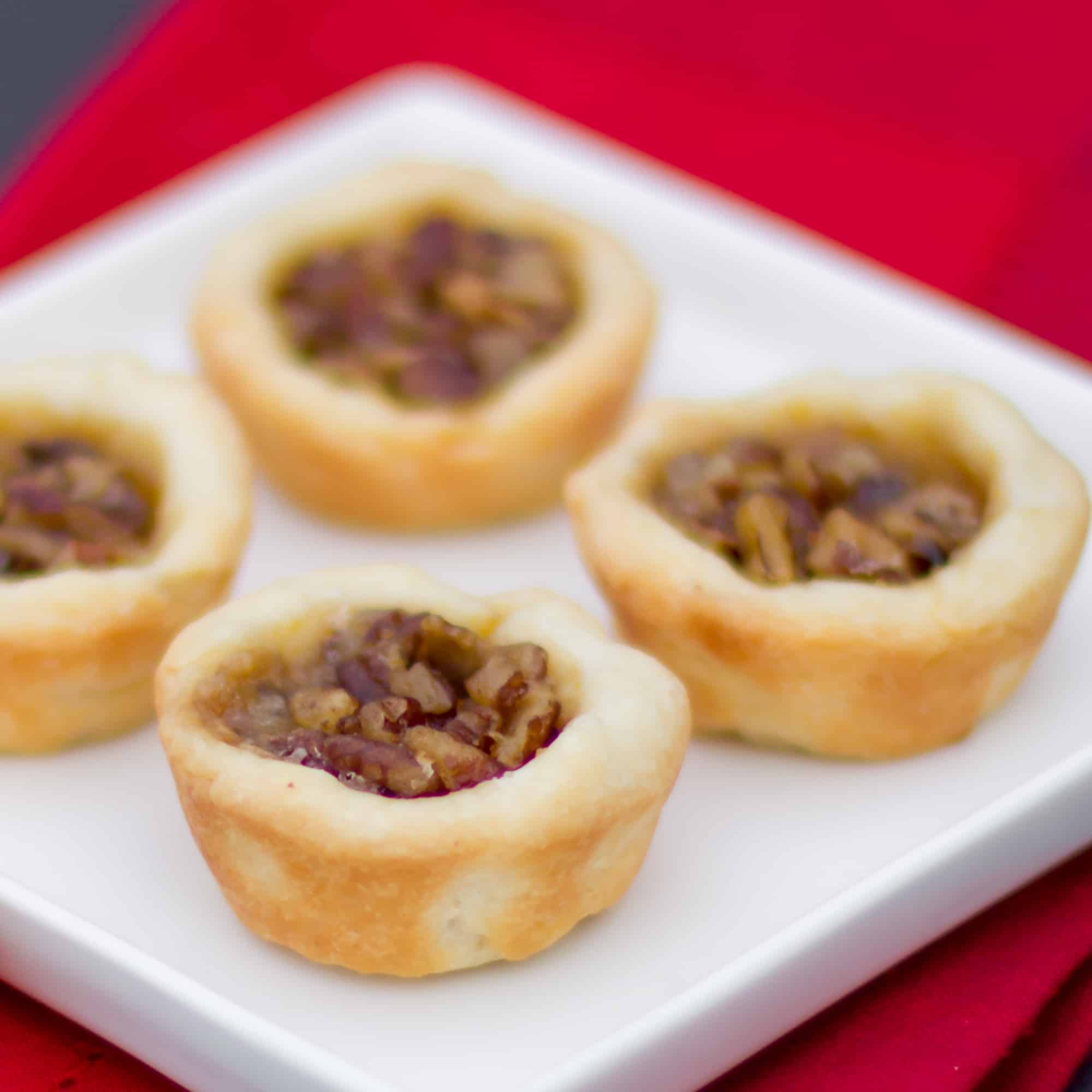 Maple syrup and pecans make up the filling in these mini tarts tassies that are simple and delicious. Cream cheese and butter pastry.