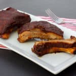 Slow braised ribs with rub and bourbon bbq sauce recipe. Cook in the oven or crock pot / slow cooker. Meat is fall off the bone tender.