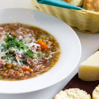 A warm bowl of soup with fresh baked biscuits.