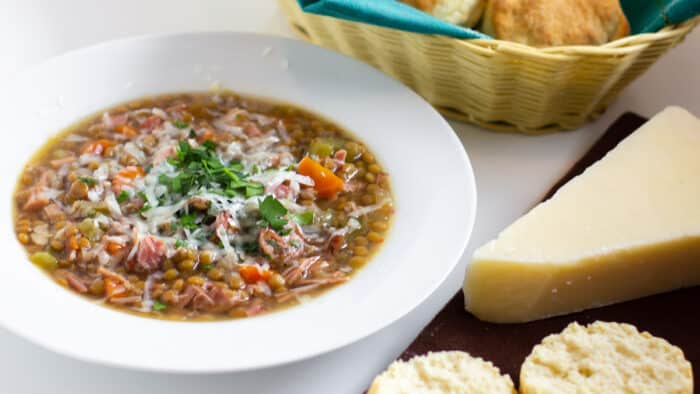 A warm bowl of soup with fresh baked biscuits.