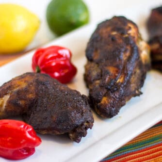 A plate of baked chicken with jerk seasoning.