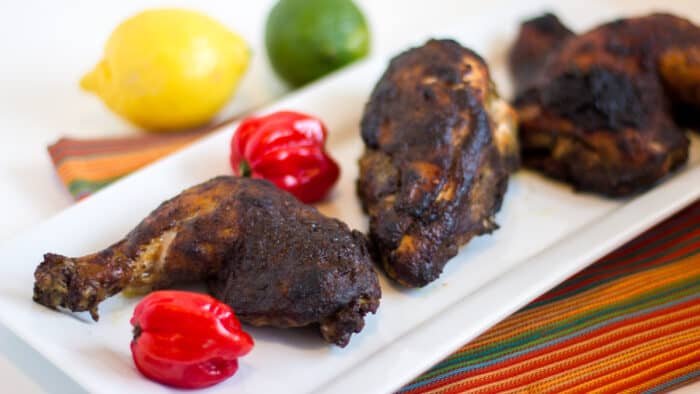 A plate of baked chicken with jerk seasoning.