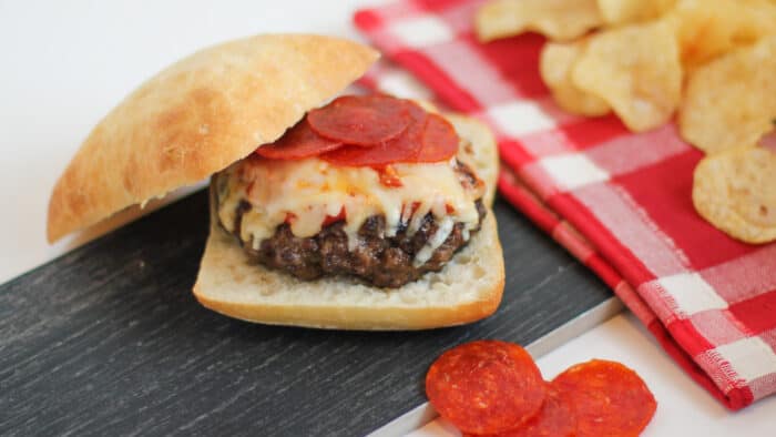 Homemade burger patty with pizza sauce, mozzarella cheese and sliced pepperoni.