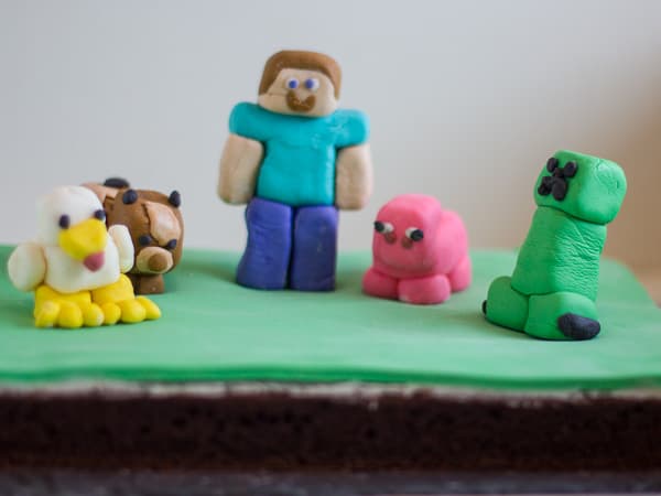 A Minecraft cake! I cheated and used figures for the top… I find kids love to get a toy with their cake! : r/cakedecorating