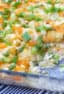Creamy and cheesy chicken casserole with cream of mushroom soup, sour cream peas and tater tots and grated cheddar. Easy comfort food.