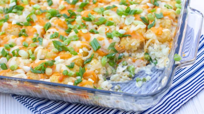 Creamy and cheesy chicken casserole with cream of mushroom soup, sour cream peas and tater tots and grated cheddar. Easy comfort food.