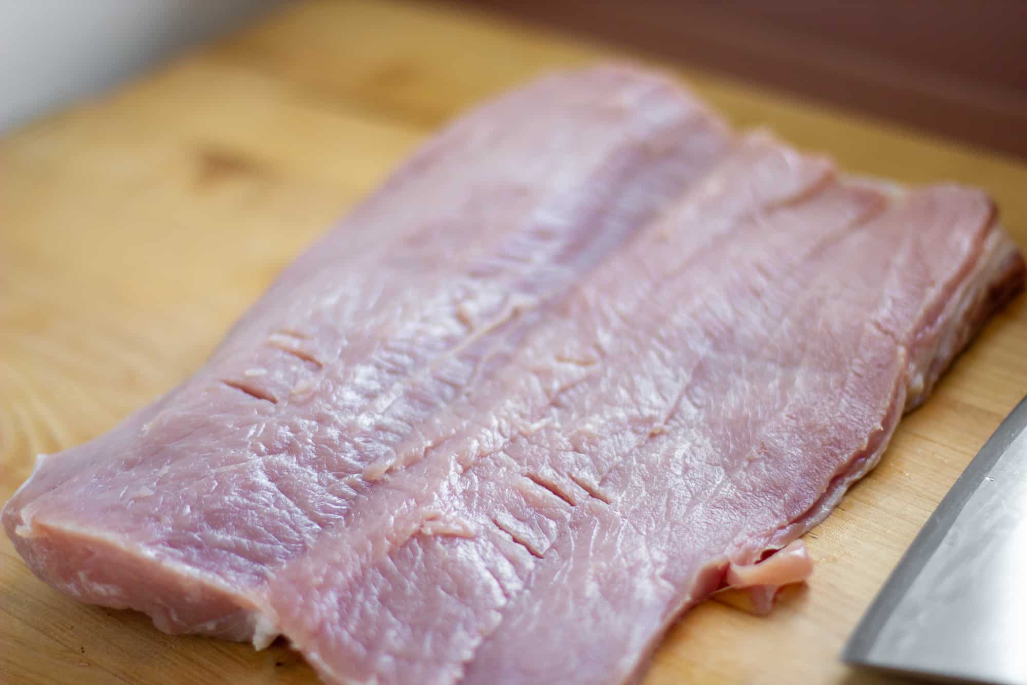 Trim the pork loin of any excess fat and butterfly it with a sharp knife.