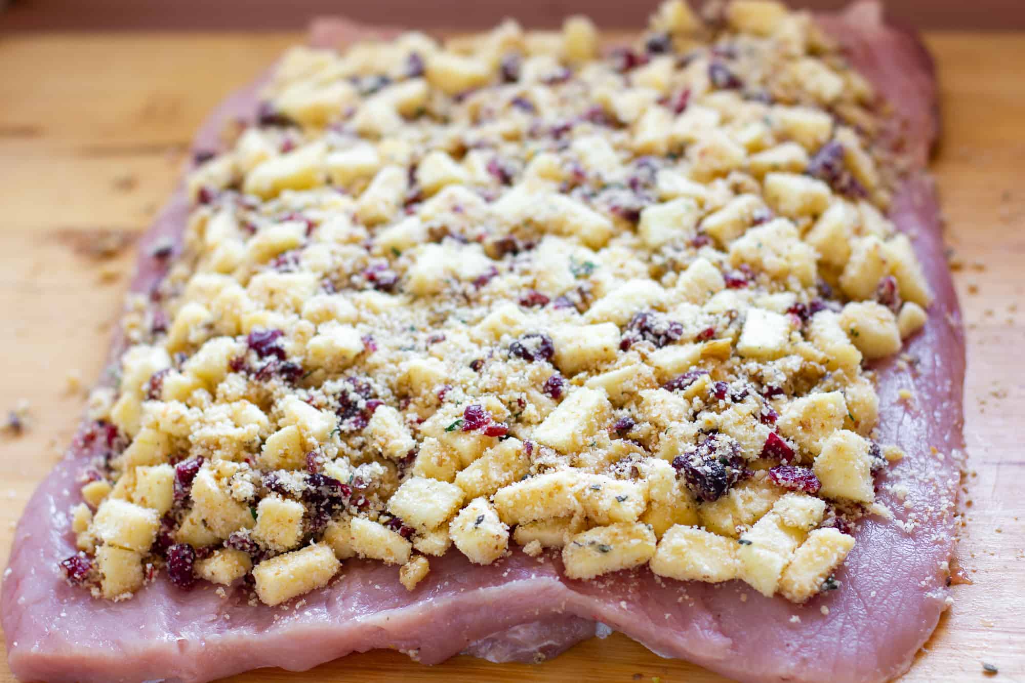 Evenly spread the filling on the flattened pork loin.