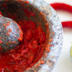 Easy instructions for how to make sambal oelek homemade from scratch using fresh red chili pepers, lime juice and salt.