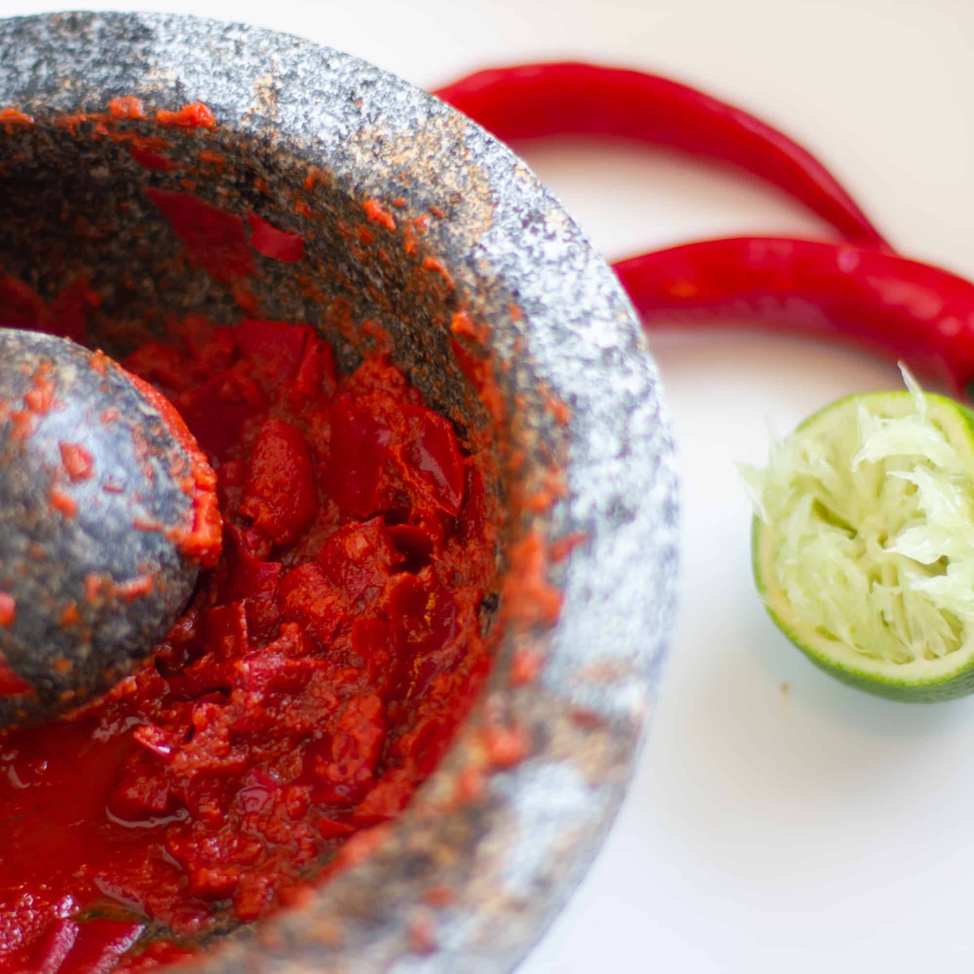 Mortar and pestle with chili peppers.