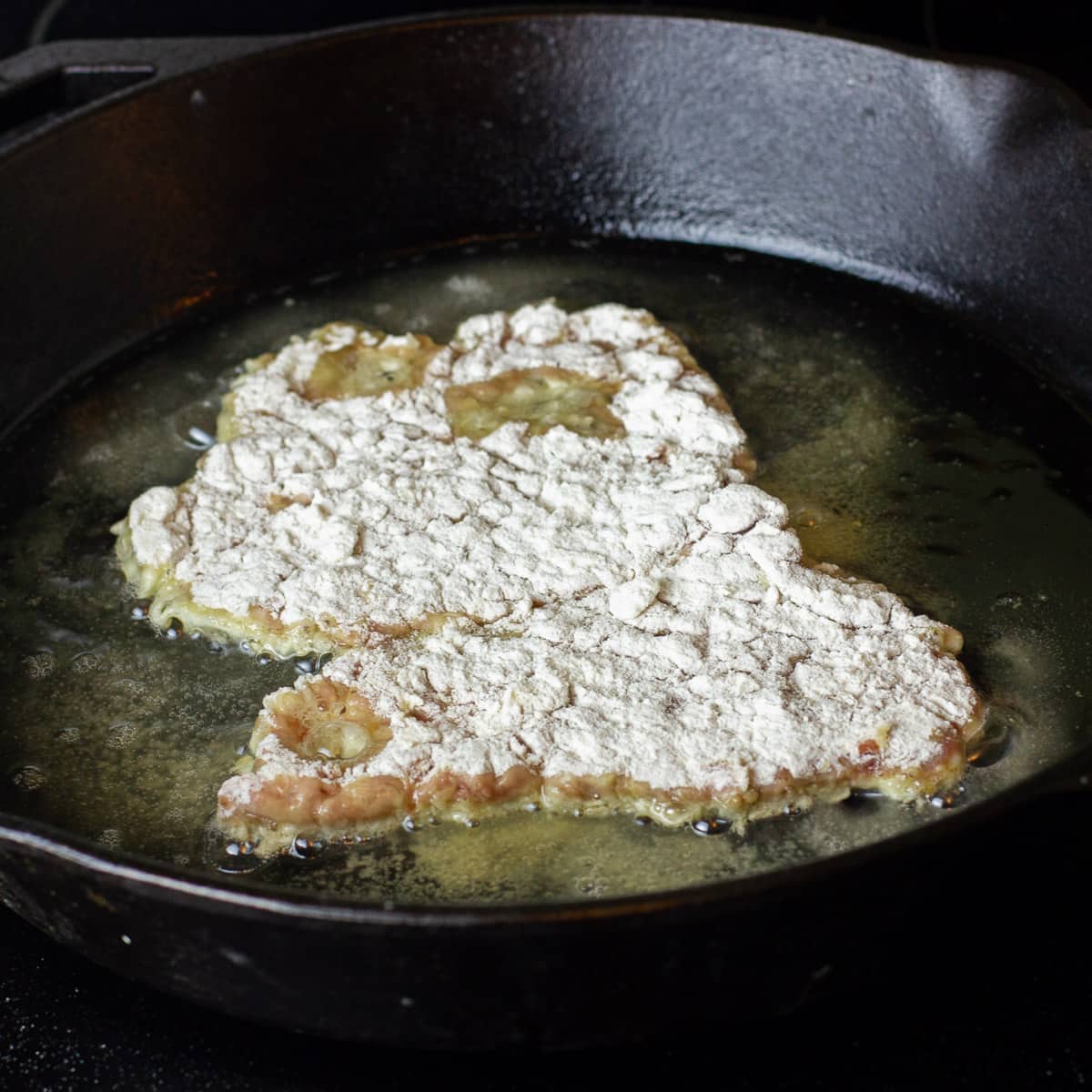 Dredge the tenderized steak with flour and egg wash.