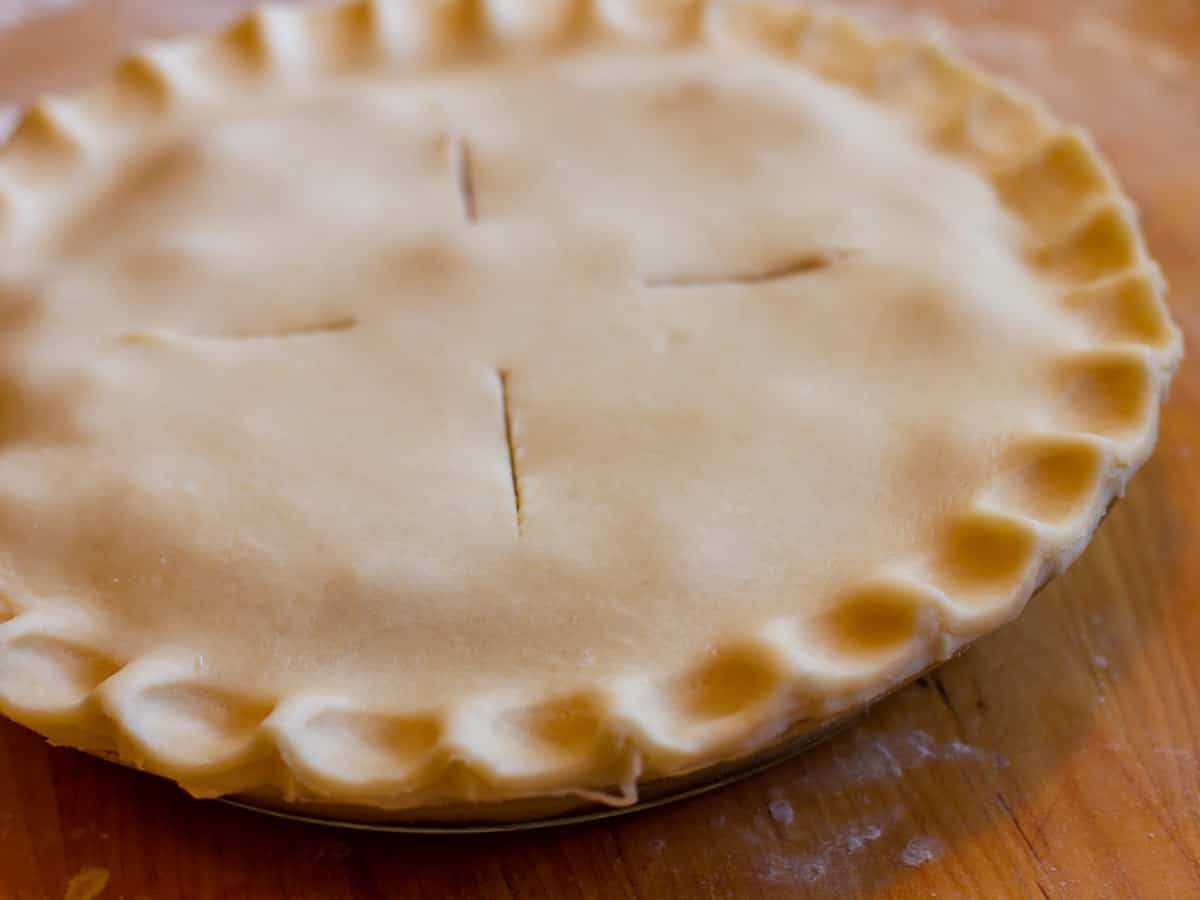 The top crust with crimped edges and four slits on top.