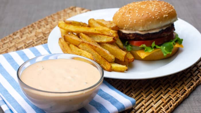 A bowl of Big Mac secret sauce with a burger and fries.